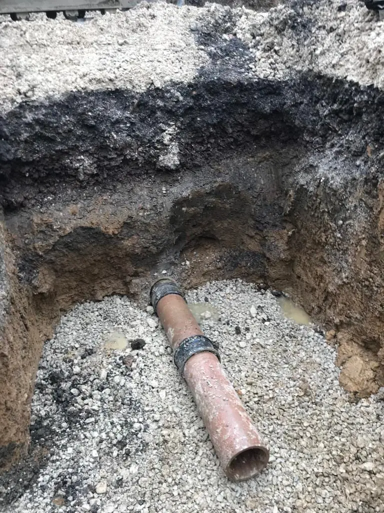 Sectioned ground showing newly laid drainage pipe and its bedding