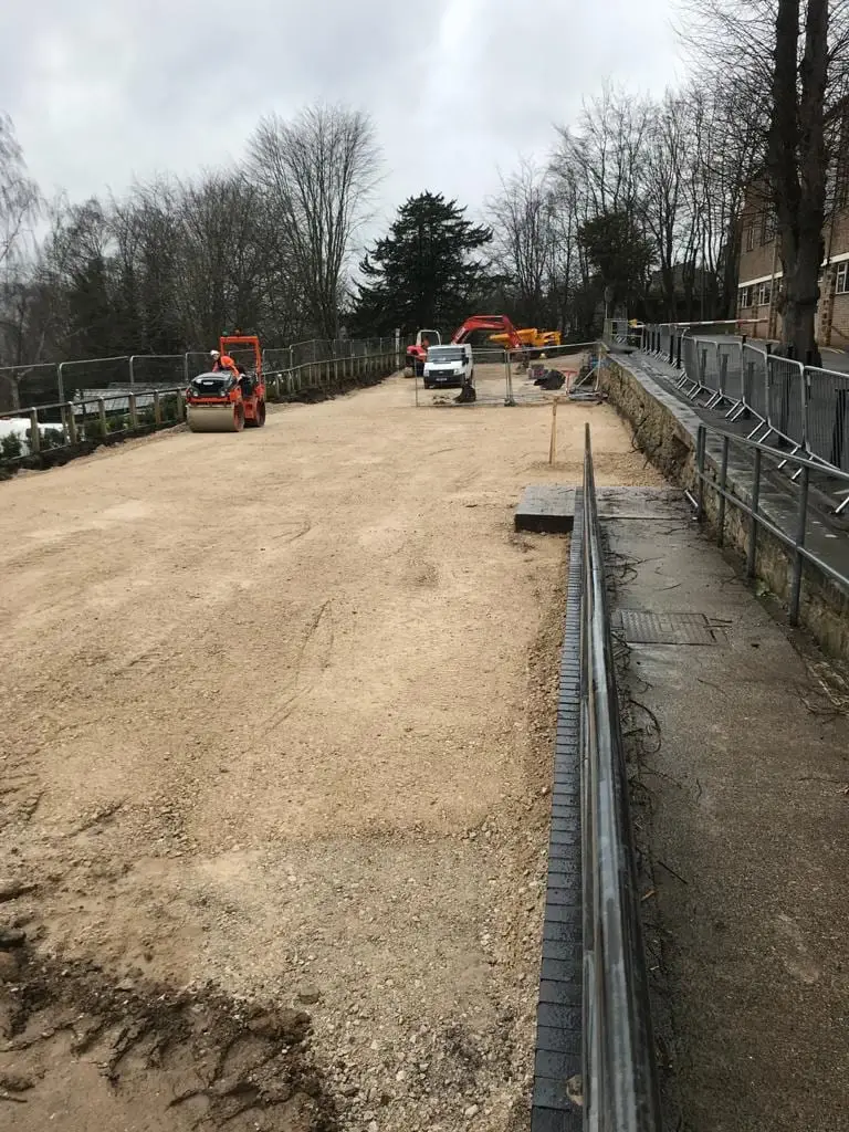 Newly laid kerbing along a tree-lined carriageway