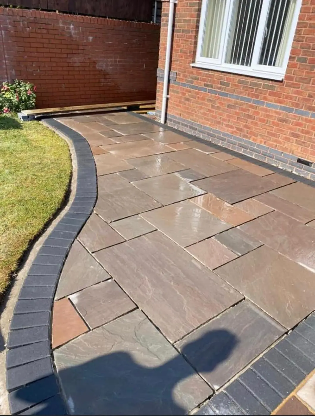Indian sandstone patio finished with a contrasting charcoal border